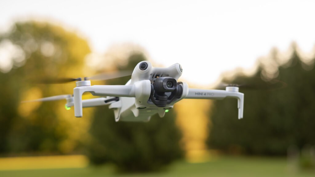 DJI Mini Pro 4 Drone flying with trees in the background